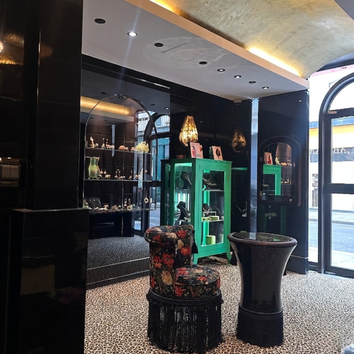 Boutique Garnazelle Paris — vitrine verte, tabouret floral et entrée arquée